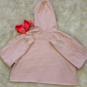 A cropped comfy hoodie, in the color baby pink, great for jogs or runs
